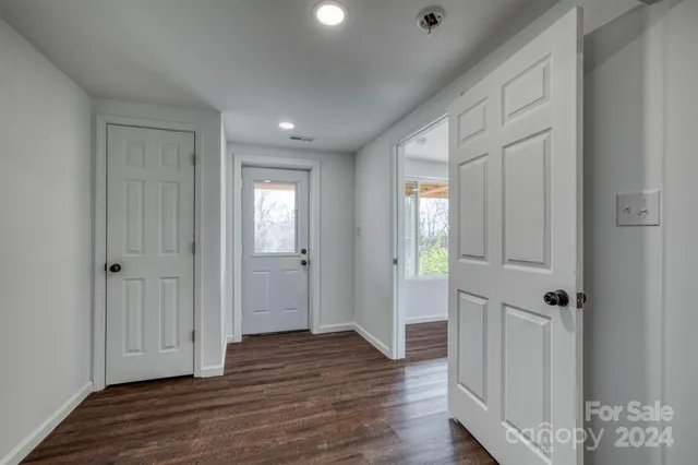 a view of a hallway with wooden floor and closet area