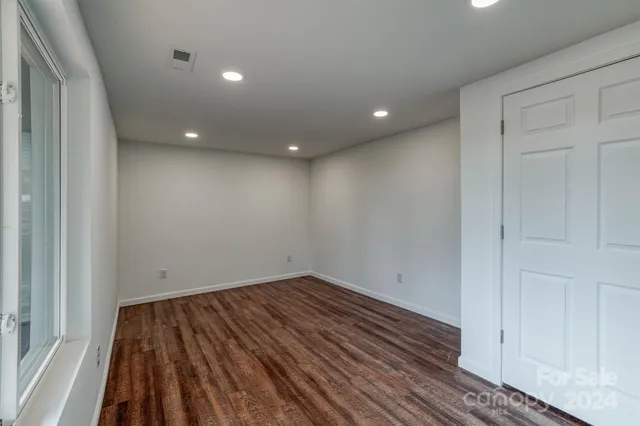 a view of empty room with wooden floor