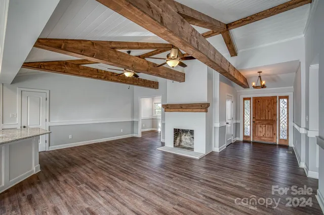 a view of empty room with wooden floor and fireplace