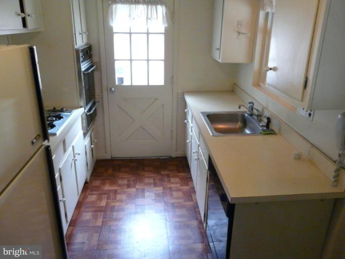 705 Stirling Road Silver Spring, MD 20901 - Photo 12 of 23 a kitchen with stainless steel appliances a stove a sink and a refrigerator