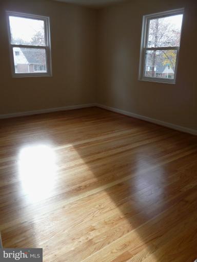 705 Stirling Road Silver Spring, MD 20901 - Photo 19 of 23 an empty room with wooden floor and windows