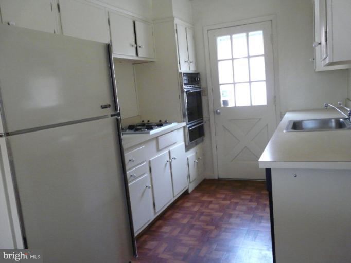 705 Stirling Road Silver Spring, MD 20901 - Photo 20 of 23 a kitchen with white cabinets and refrigerator