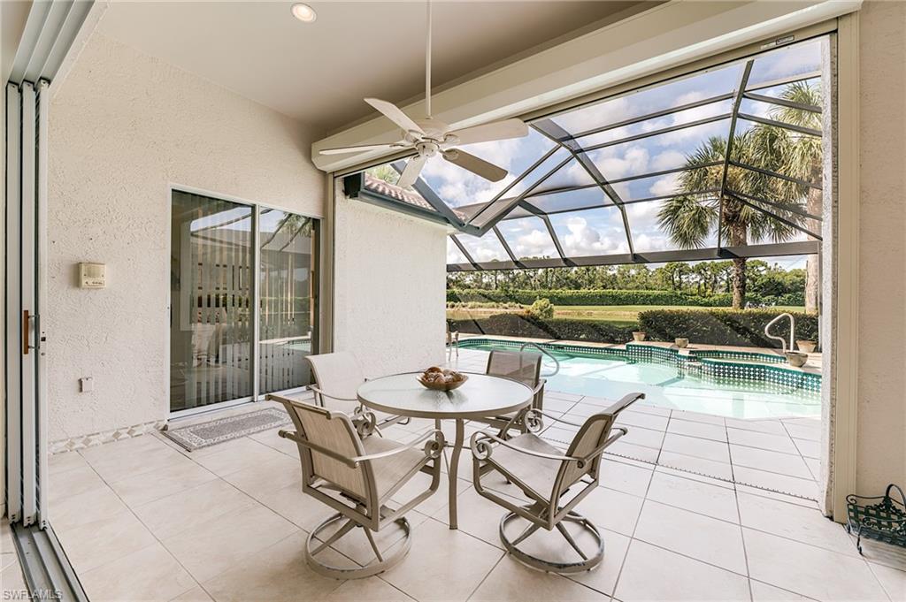 9156 Spring Run Boulevard Estero, FL 34135 - Photo 27 of 34 a dining room with furniture and a floor to ceiling window