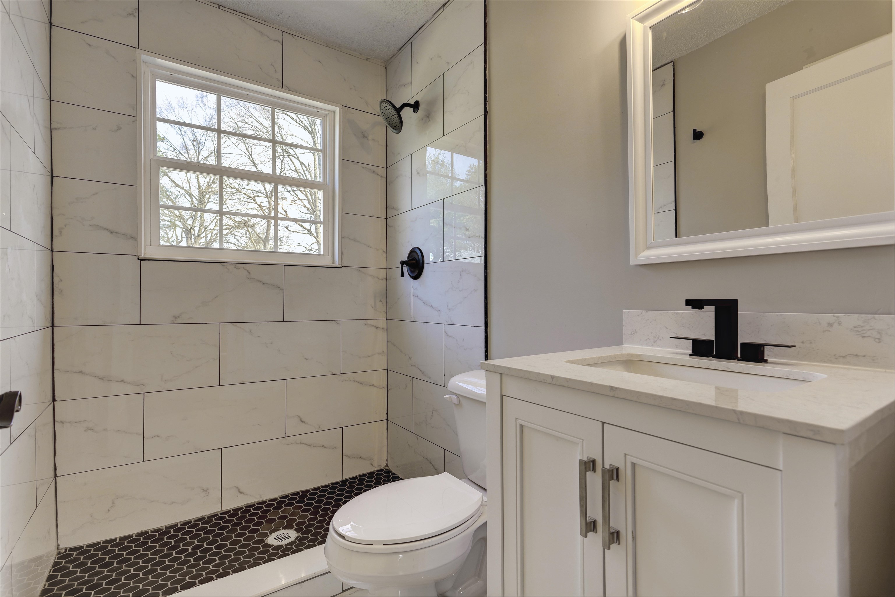 942 Wingfield Road Memphis, TN 38122 - Photo 20 of 24 a bathroom with a granite countertop toilet a sink a mirror and shower