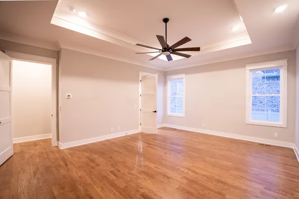 a view of an empty room with window and wooden floor