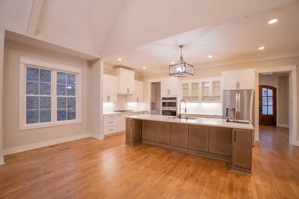 a large kitchen with granite countertop a large counter top and stainless steel appliances
