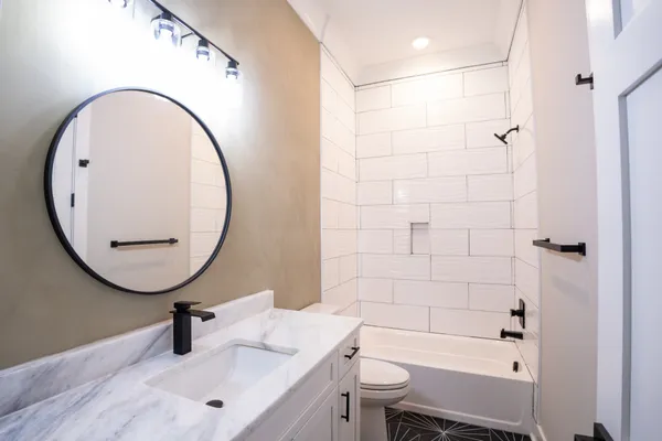 a bathroom with a sink a toilet and a mirror