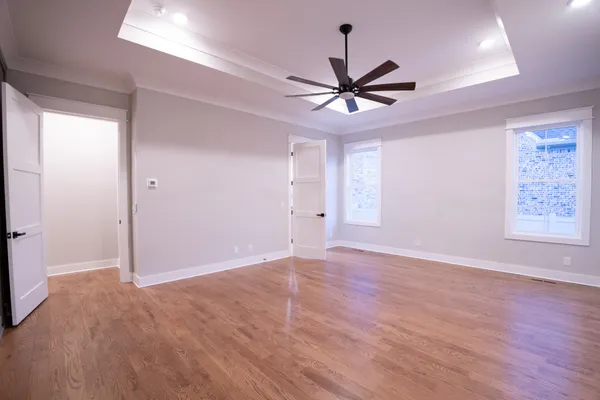 a view of a big room with wooden floor closet and ceiling fan