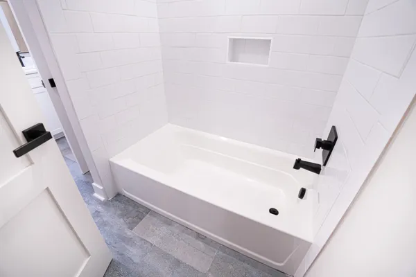 an empty room with wooden floor ceiling fan and windows