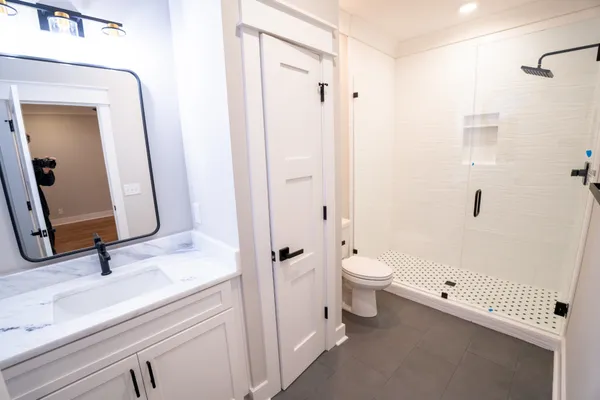 a bathroom with a granite countertop shower and a window