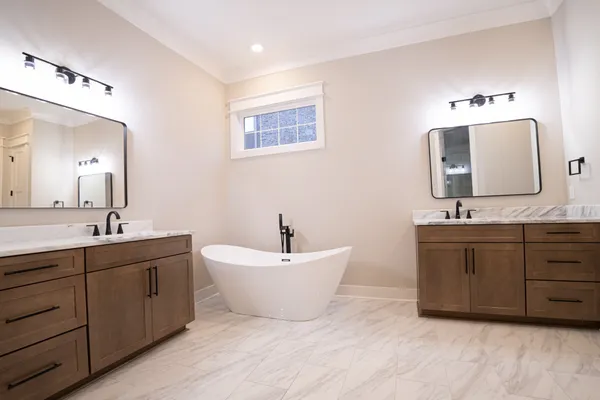 a spacious bathroom with a double vanity sink double mirror and bathtub
