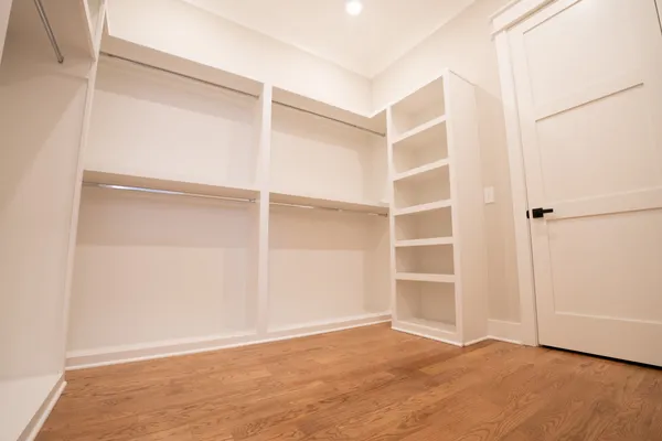 a view of an empty room with a closet and wooden floor