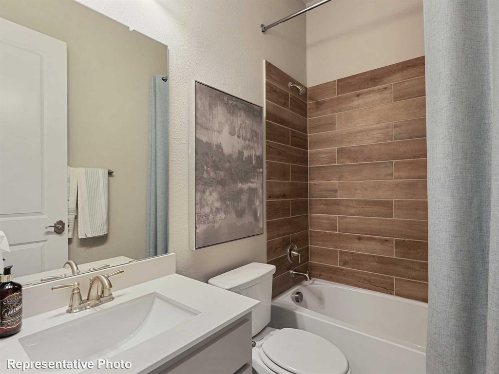 1143 Rothland Lane Red Oak, TX 75154 - Photo 15 of 18 Bathroom featuring a single vanity with an integrated sink, brushed nickel faucet, and a shower-tub combination