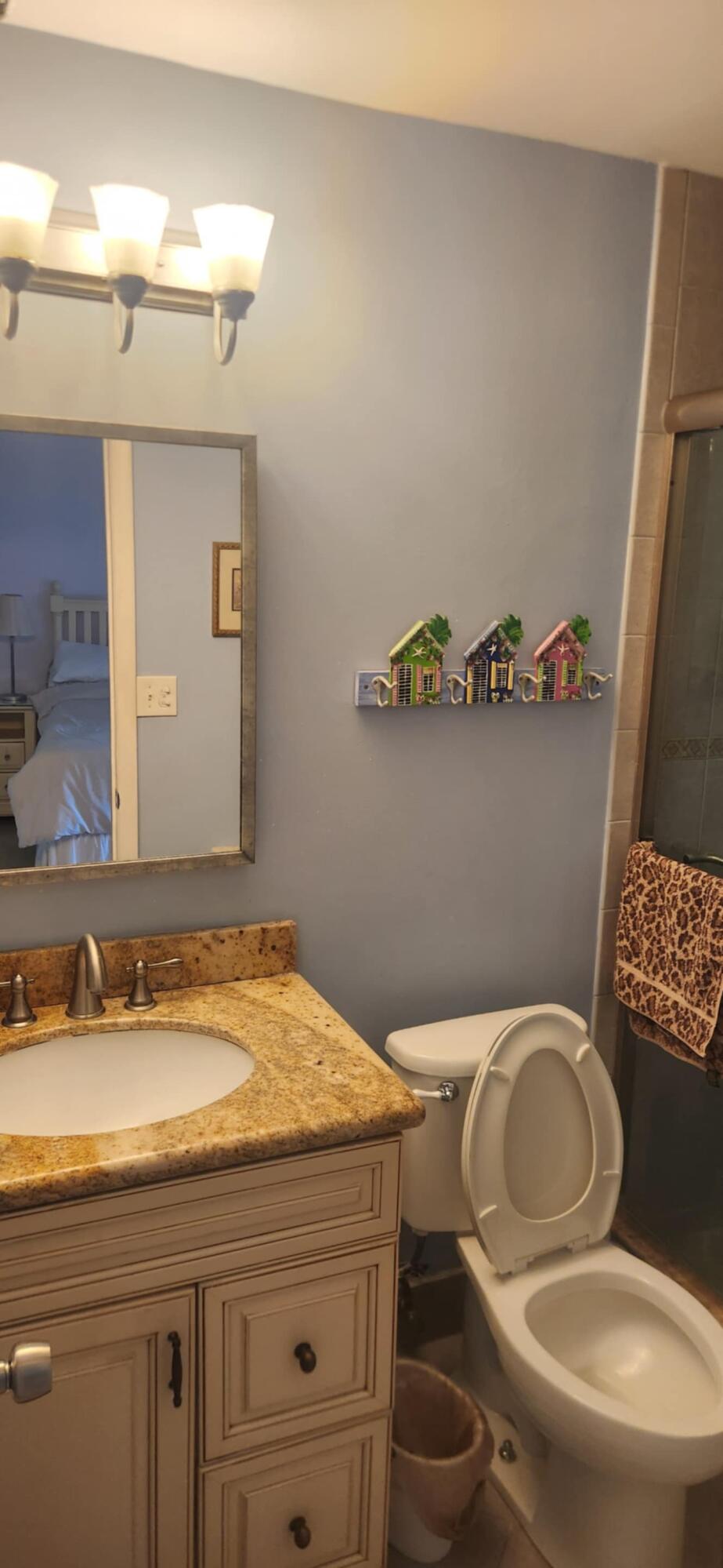 5510 North Ocean Boulevard, Unit 206 Ocean Ridge, FL 33435 - Photo 10 of 23 a bathroom with a granite countertop toilet sink and mirror