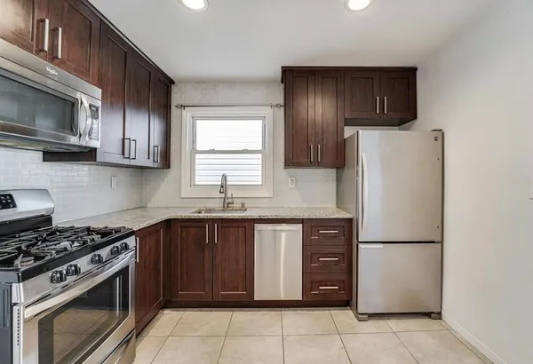 a kitchen with stainless steel appliances granite countertop a refrigerator stove a sink dishwasher and microwave