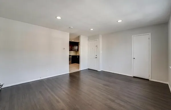 a view of an empty room with wooden floor and closet