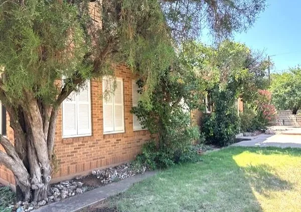 a view of a house with backyard and trees