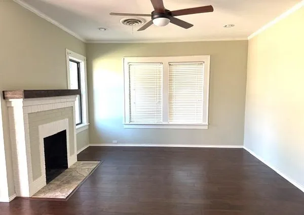 a view of empty room with wooden floor and fireplace