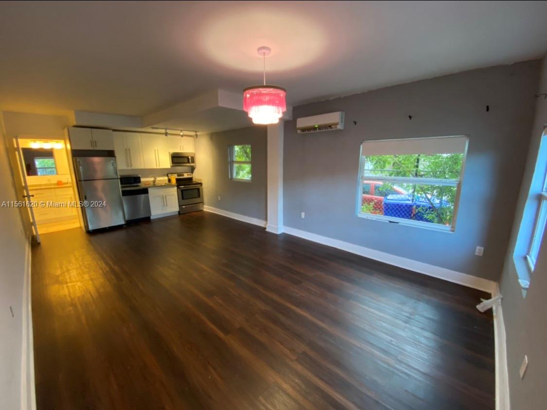 a view of a living room with kitchen view and wooden floor
