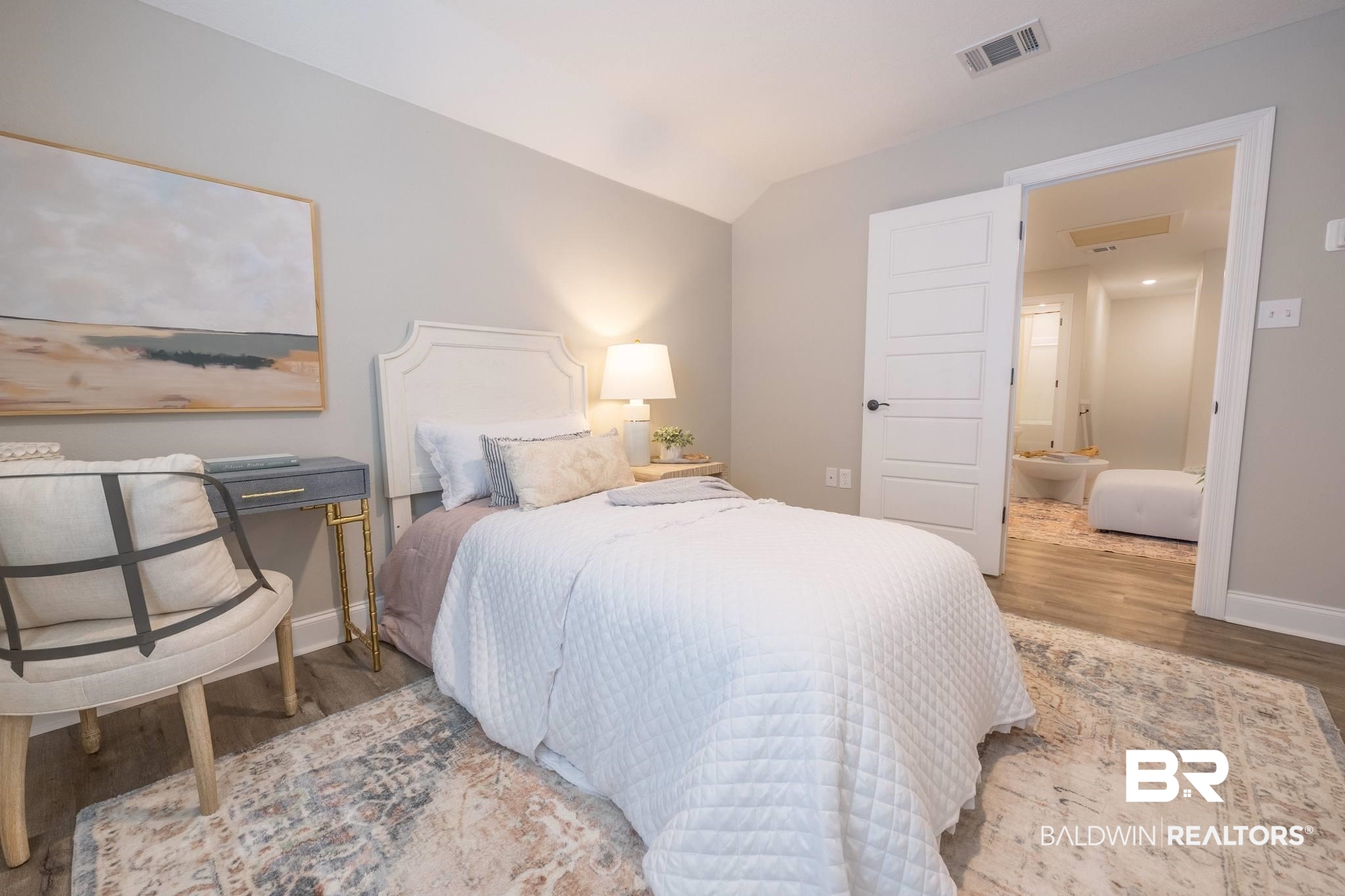 12918 Flanagan Street Elberta, AL 36530 - Photo 19 of 33 Light gray wall paint, wood-finish flooring, and a white headboard complement the room's aesthetic