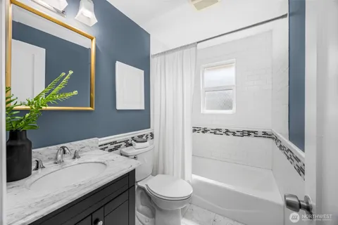 a bathroom with a granite countertop sink a toilet and shower