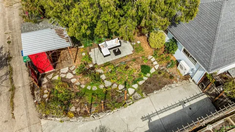 an aerial view of a house with a yard and large tree