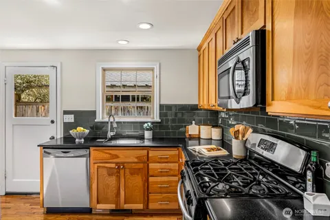 a kitchen with granite countertop a stove and cabinets