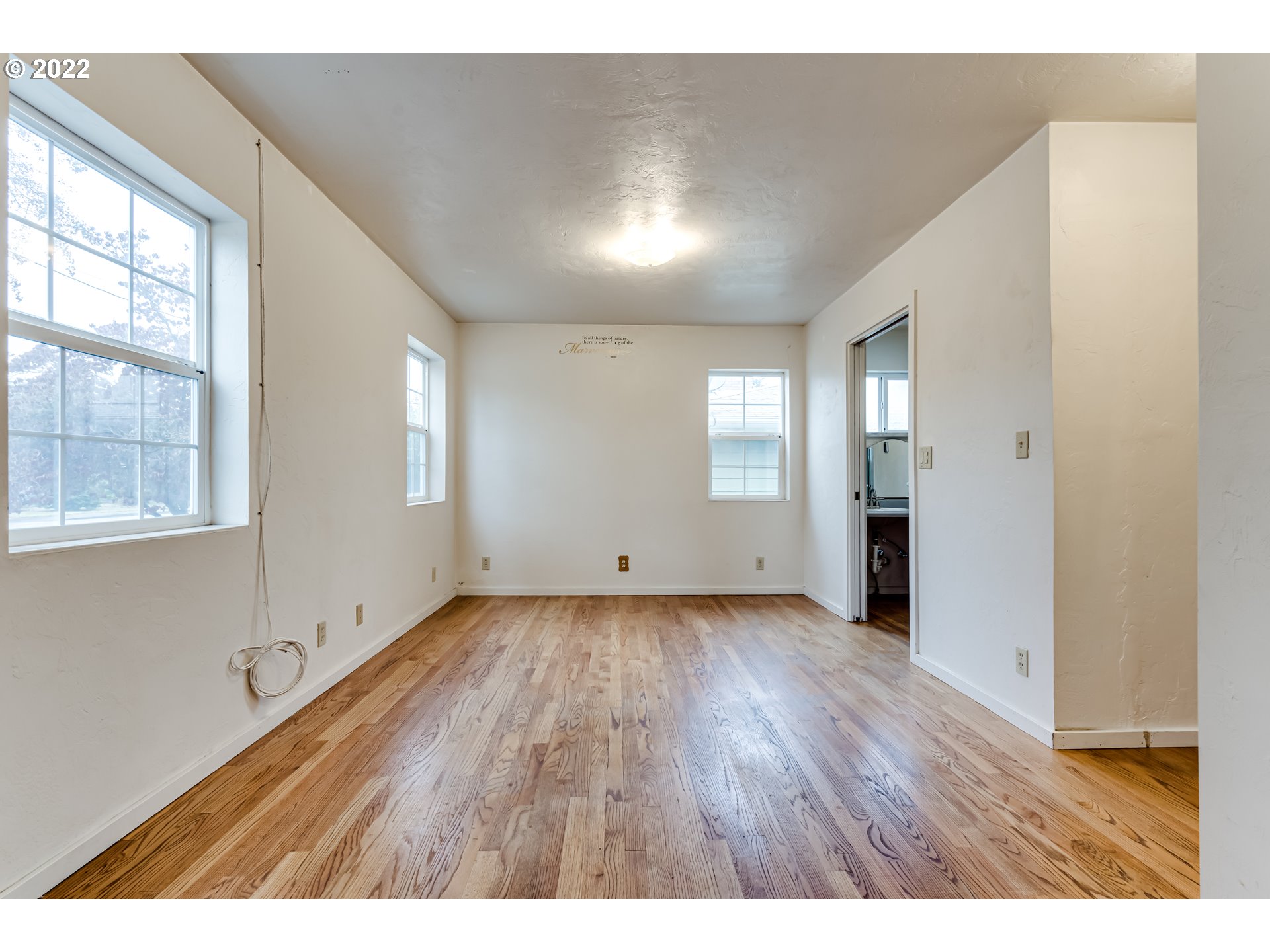 2261 5th Street Springfield, OR 97477 - Photo 6 of 27 a view of an empty room with wooden floor and windows