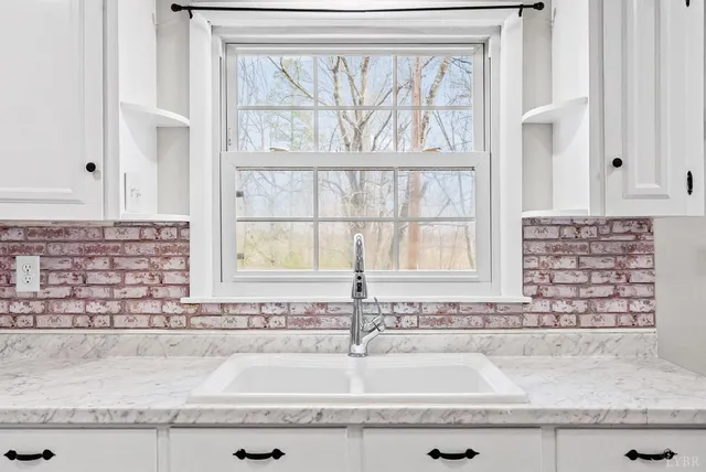 a bathroom with a granite countertop sink and window