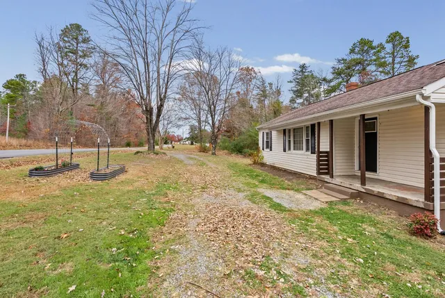 a view of a house with backyard and trees
