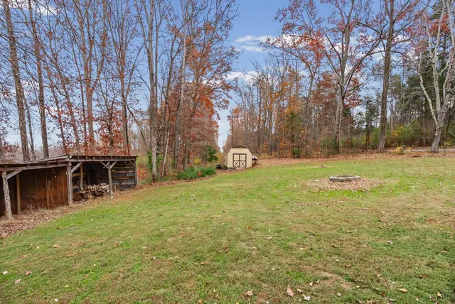 a view of a house with backyard and trees