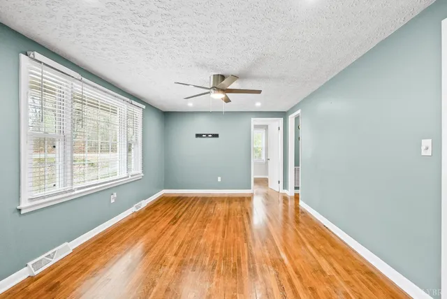 a view of a livingroom with wooden floor and a ceiling fan
