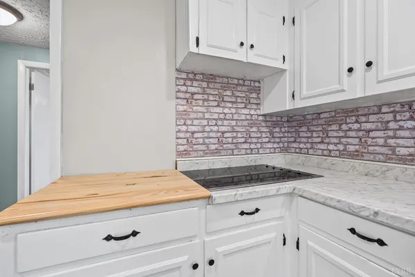 a kitchen with granite countertop white cabinets and white appliances