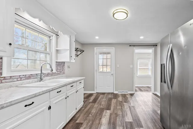 a spacious bathroom with a granite countertop sink a mirror and a shower