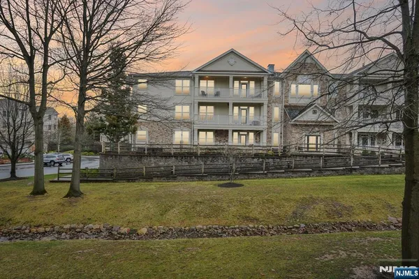 a view of a large pool with lawn chairs under an umbrella
