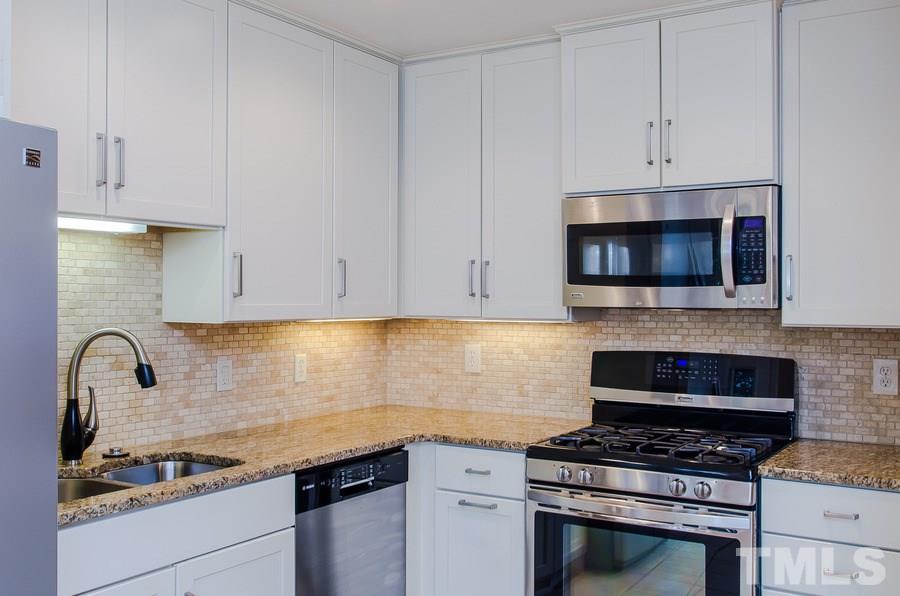 2705 Wycliff Road Raleigh, NC 27607 - Photo 10 of 22 a kitchen with granite countertop a stove a microwave and cabinets
