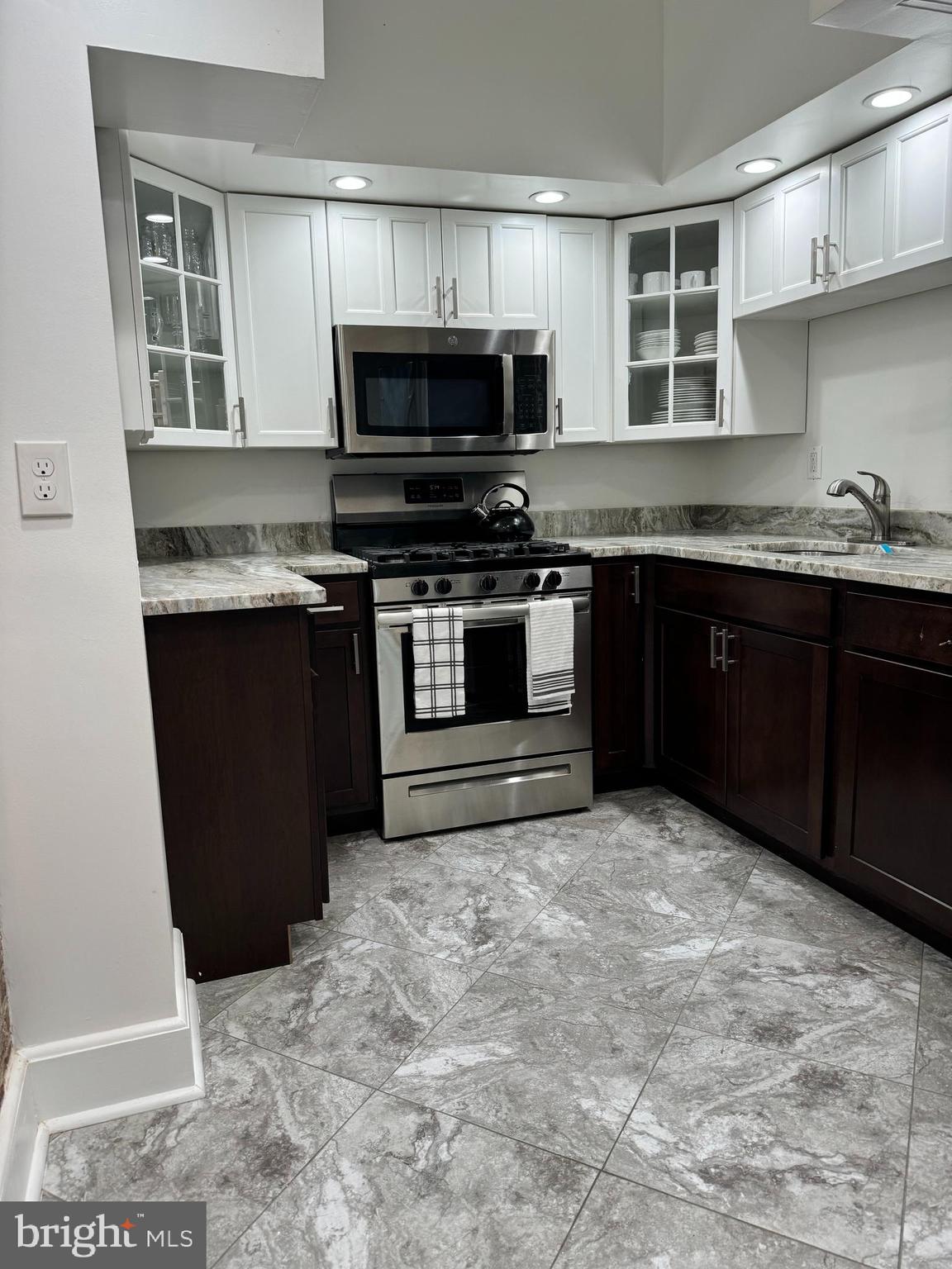 3401 Greenway, Unit 50 Baltimore, MD 21218 - Photo 5 of 12 a kitchen with stainless steel appliances granite countertop a stove top oven a sink dishwasher and a microwave oven on the blue kitchen countertops