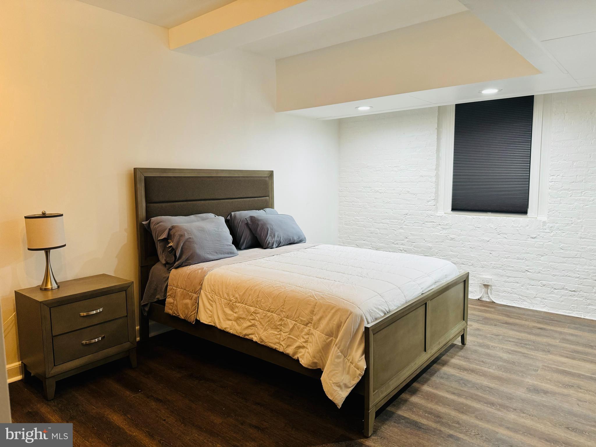 3401 Greenway, Unit 50 Baltimore, MD 21218 - Photo 7 of 12 a bedroom with a bed and a night stand