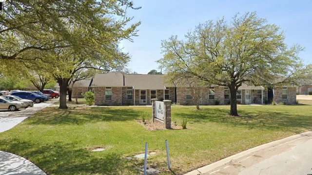 a house with huge green field and trees