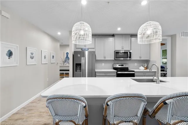 a kitchen with stainless steel appliances a dining table and chairs
