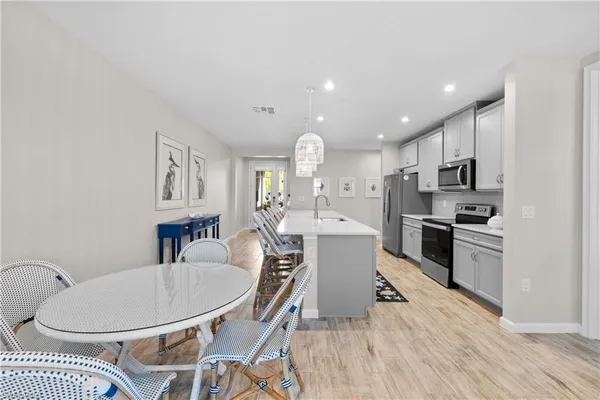a kitchen with kitchen island a appliances dining table and chairs