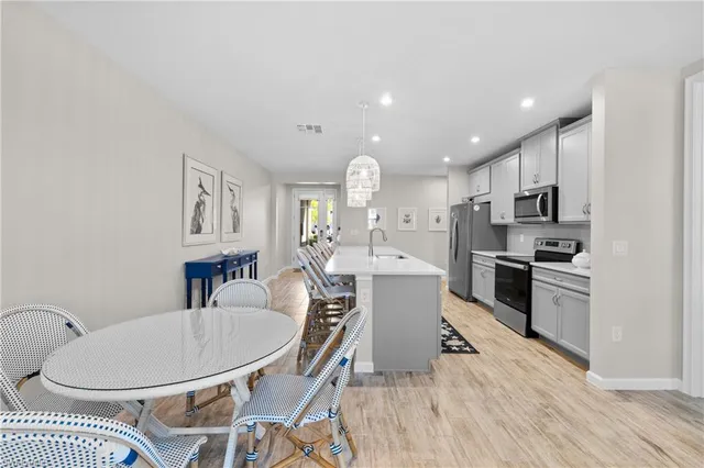 a kitchen with kitchen island a appliances dining table and chairs