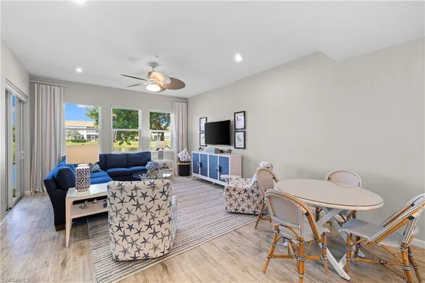 a living room with furniture a flat screen tv and a window