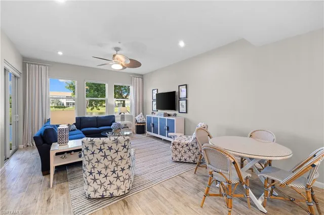 a living room with furniture a flat screen tv and a window