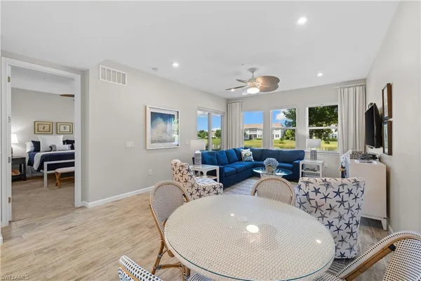 a living room with furniture a large window and a chandelier