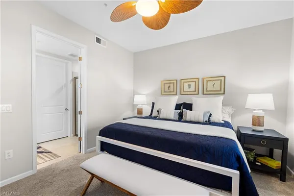 a bedroom with a bed and a lamp on dresser