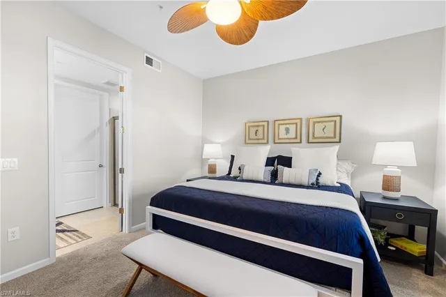 a bedroom with a bed and a lamp on dresser