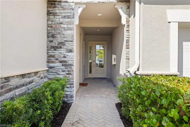 a view of a entryway door with potted plants in front of door