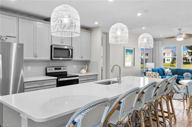 a kitchen with stainless steel appliances a stove a sink a microwave and a refrigerator