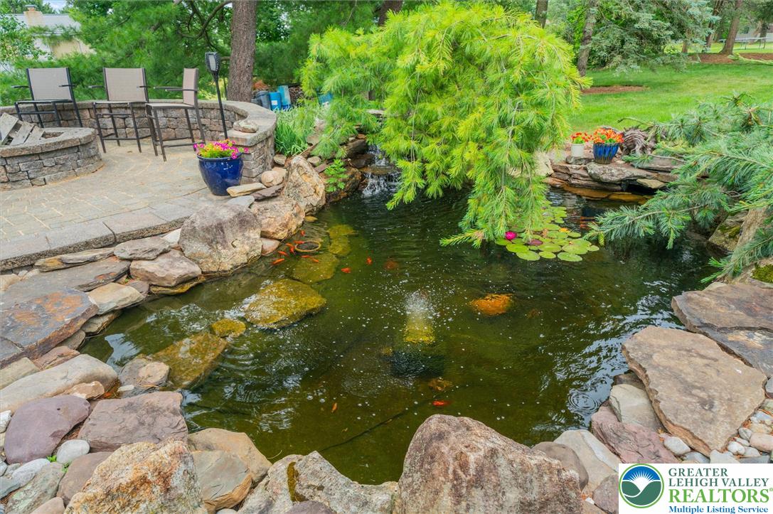 5616 Snowdrift Road Orefield, PA 18069 - Photo 30 of 36 Lush landscaping surrounds this serene koi pond, featuring a soothing waterfall and an inviting patio.